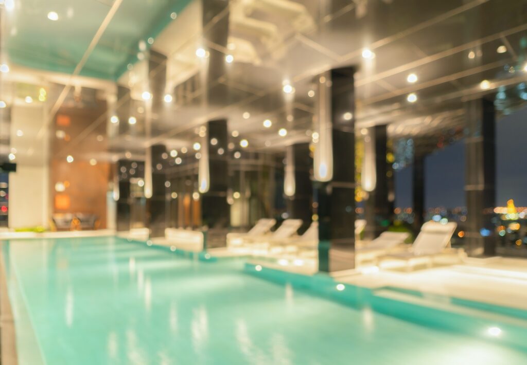Bokeh abstract background of luxury swimming pool in hotel, condominium apartment, or resort.