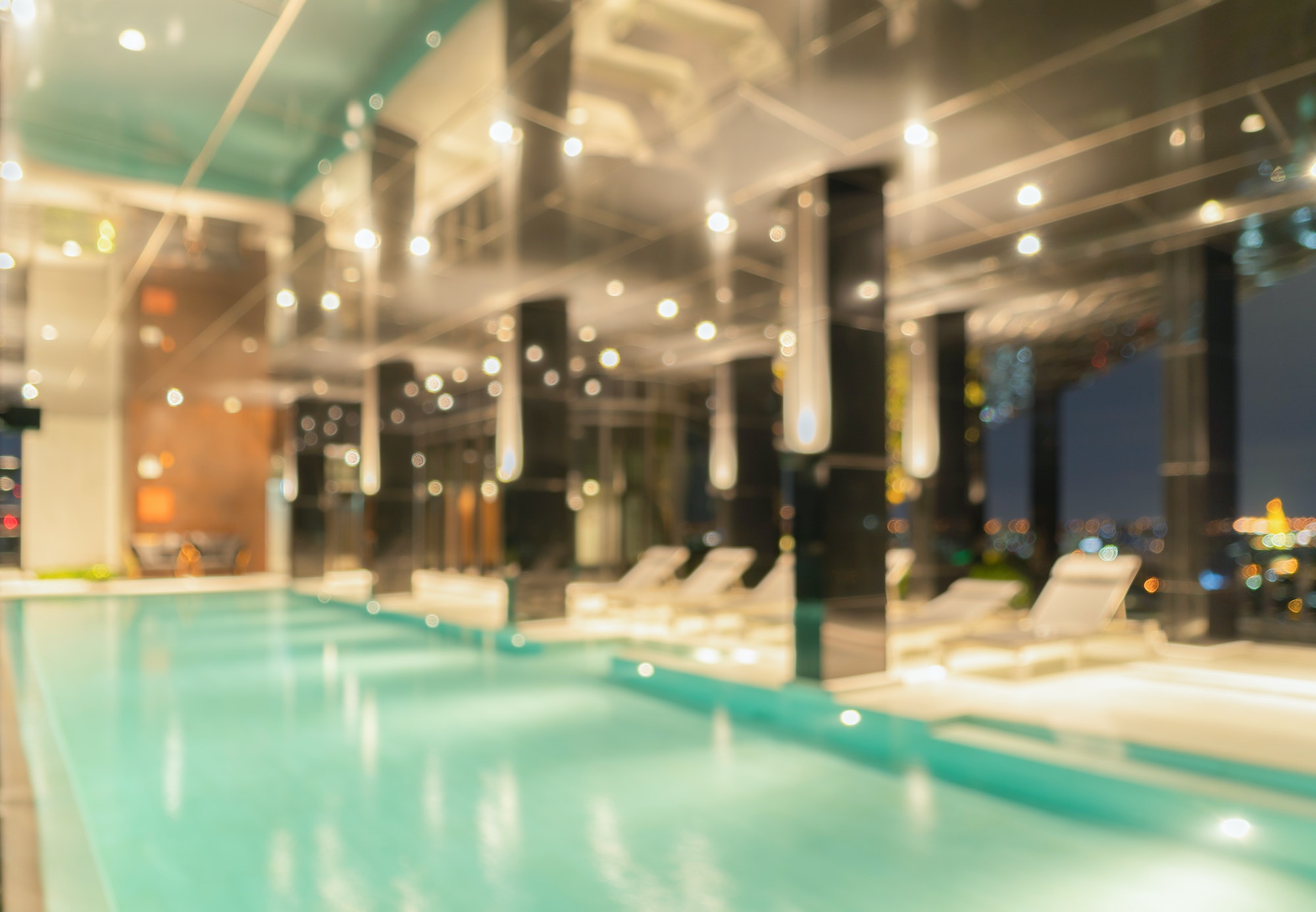 Bokeh abstract background of luxury swimming pool in hotel, condominium apartment, or resort.